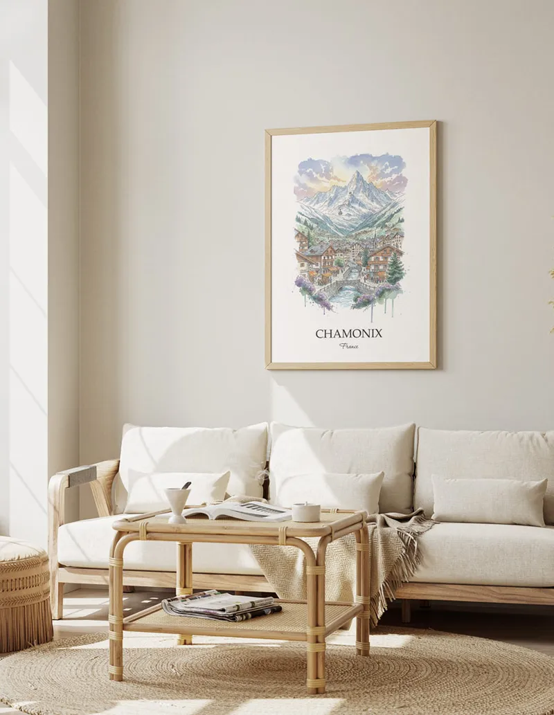 Framed wall art featuring Chamonix, France in a light wood frame hanging above a sofa in a modern living room.
