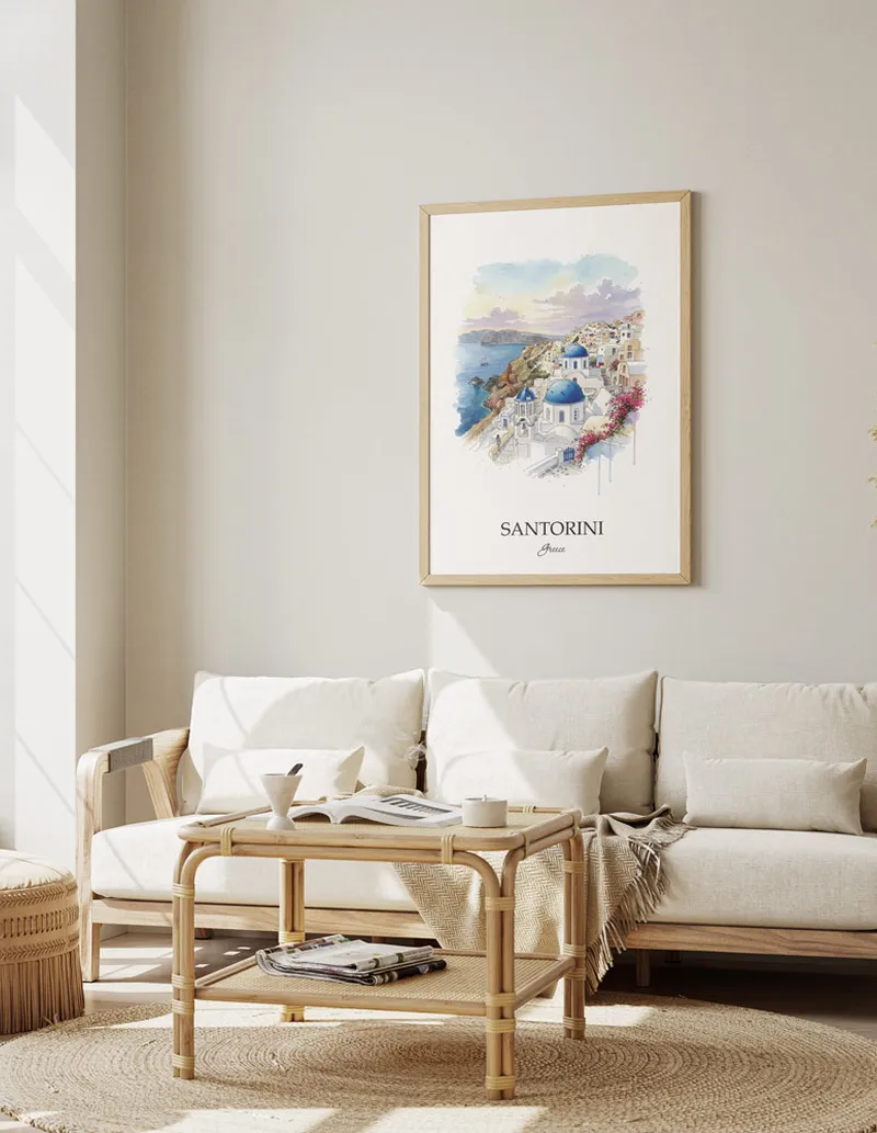 Framed wall art featuring Santorini (Oia), Greece in a light wood frame hanging above a sofa in a modern living room.