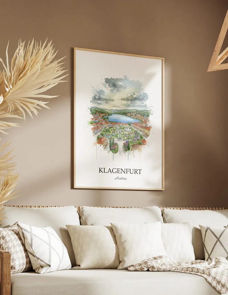 Vintage travel poster of Klagenfurt city, Austria in a light frame displayed above a sofa in a bright boho interior.