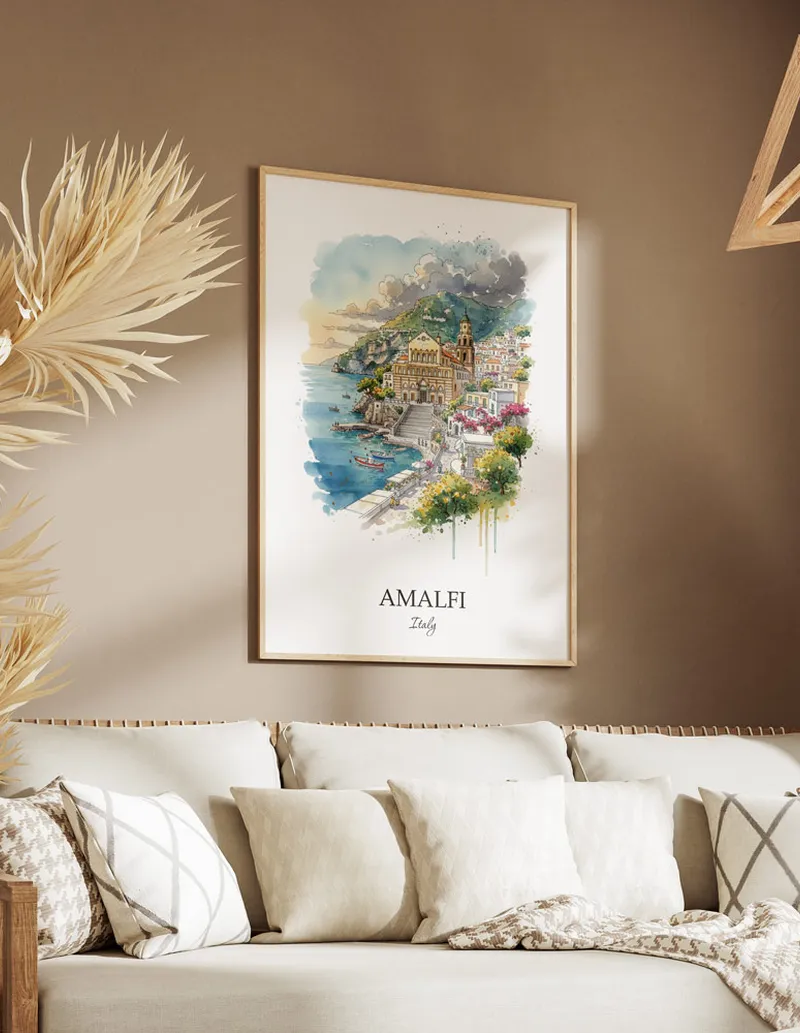 Vintage travel poster of Amalfi city, Italy in a light frame displayed above a sofa in a bright boho interior.