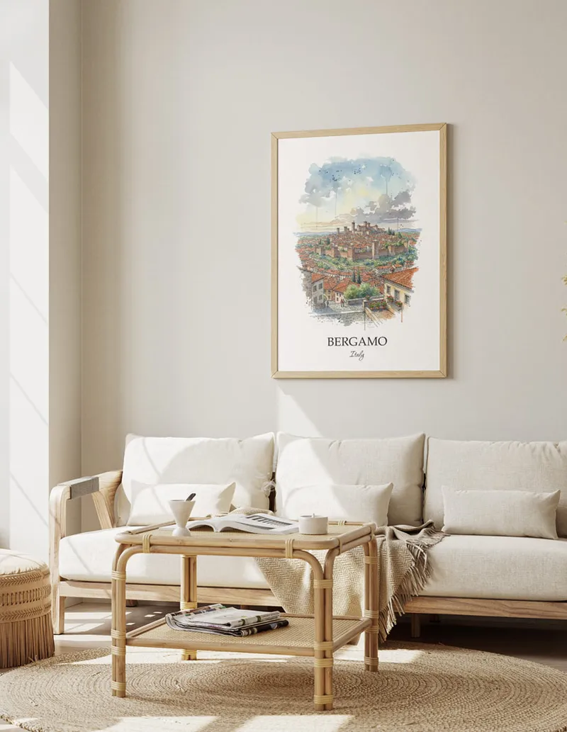 Framed wall art featuring Bergamo, Italy in a light wood frame hanging above a sofa in a modern living room.