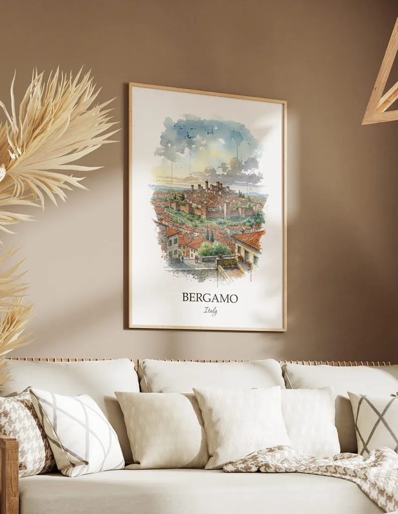 Vintage travel poster of Bergamo city, Italy in a light frame displayed above a sofa in a bright boho interior.