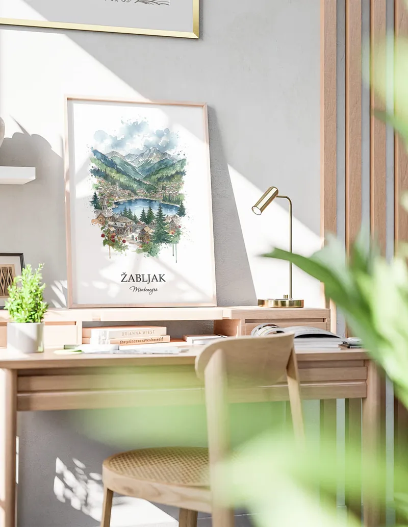 Cozy, well-lit workspace with a minimalist poster of _abljak, Montenegro in a light frame sitting on the desk.