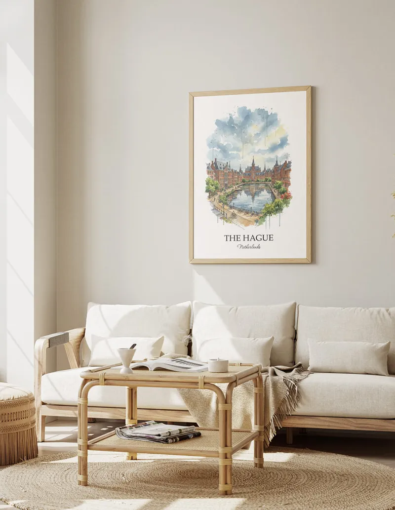 Framed wall art featuring The Hague, Netherlands in a light wood frame hanging above a sofa in a modern living room.