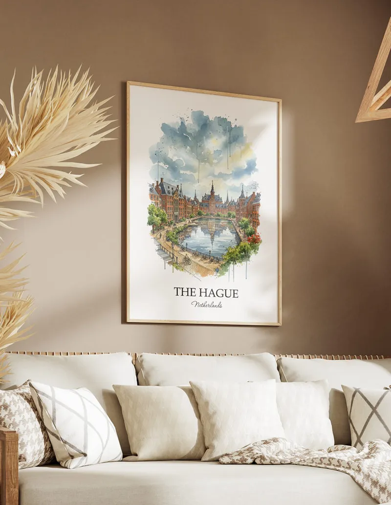 Vintage travel poster of The Hague city, Netherlands in a light frame displayed above a sofa in a bright boho interior.