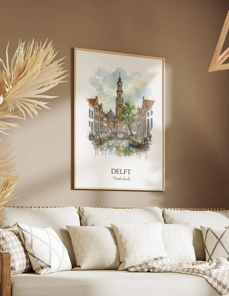 Vintage travel poster of Delft city, Netherlands in a light frame displayed above a sofa in a bright boho interior.