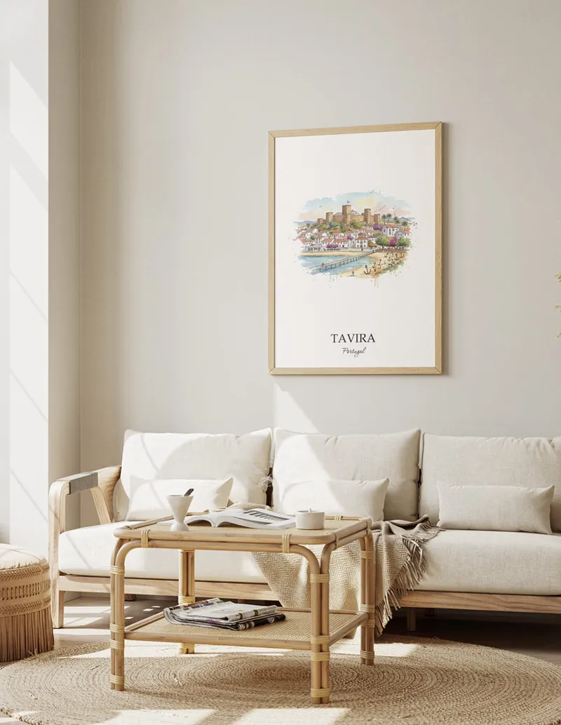 Framed wall art featuring Tavira, Portugal in a light wood frame hanging above a sofa in a modern living room.