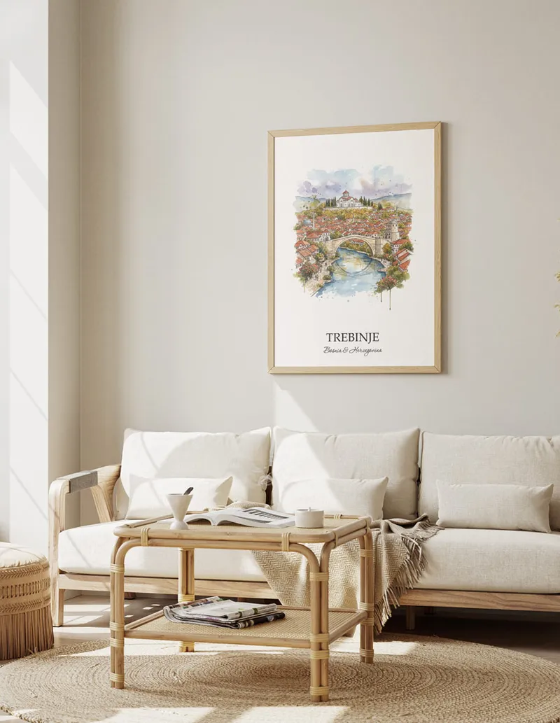 Framed wall art featuring Trebinje, Bosnia & Herzegovina in a light wood frame hanging above a sofa in a modern living room.