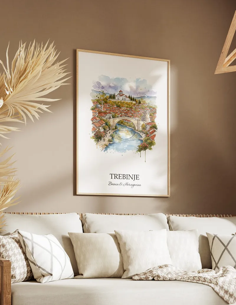 Vintage travel poster of Trebinje city, Bosnia & Herzegovina in a light frame displayed above a sofa in a bright boho interior.