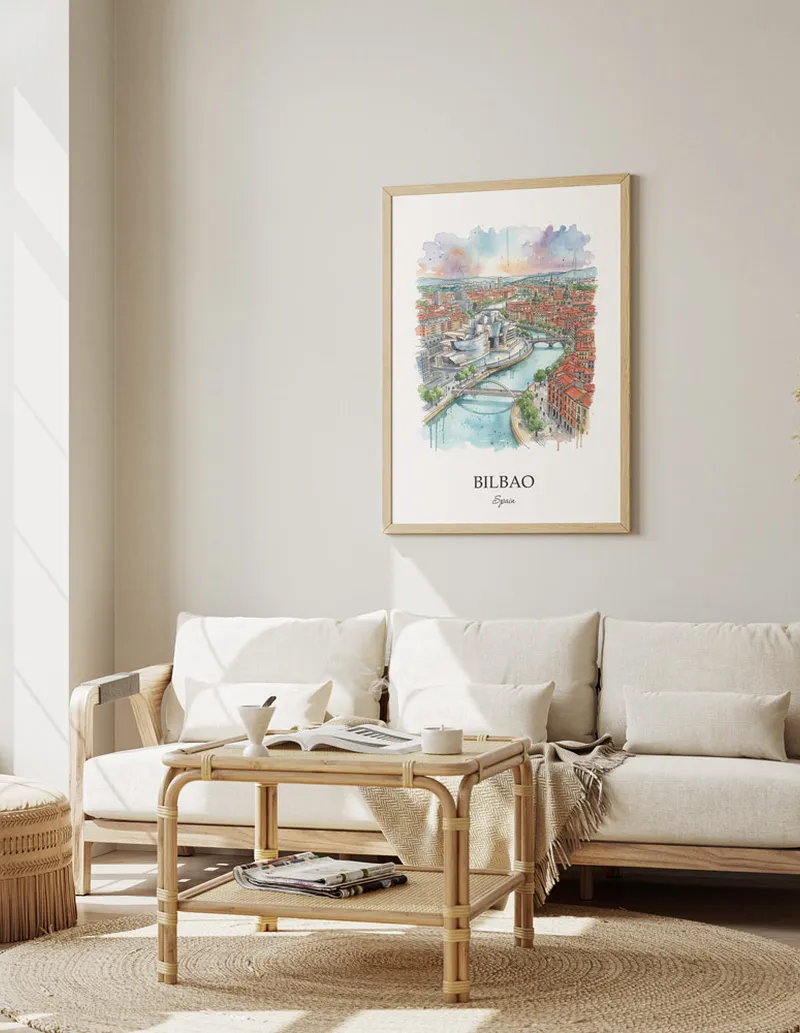 Framed wall art featuring Bilbao, Spain in a light wood frame hanging above a sofa in a modern living room.