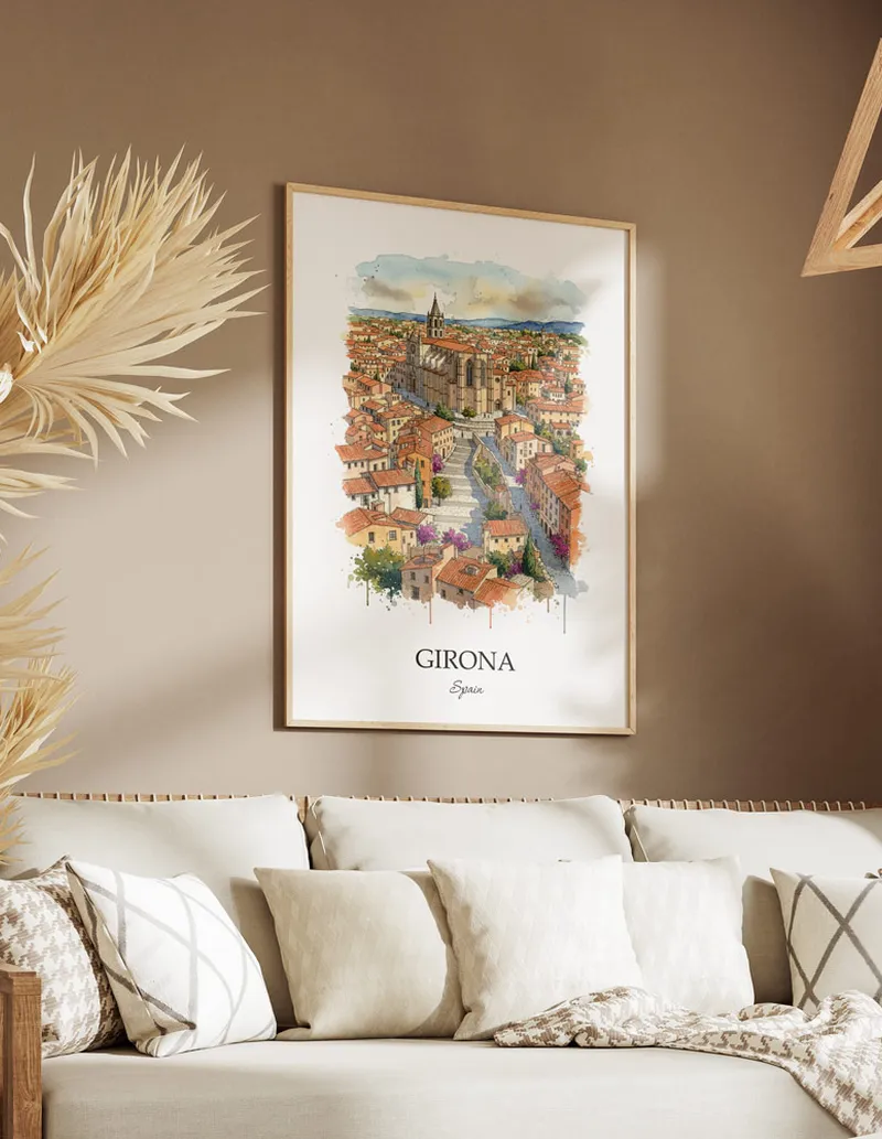 Vintage travel poster of Girona city, Spain in a light frame displayed above a sofa in a bright boho interior.