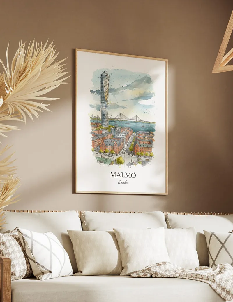 Vintage travel poster of Malmö city, Sweden in a light frame displayed above a sofa in a bright boho interior.