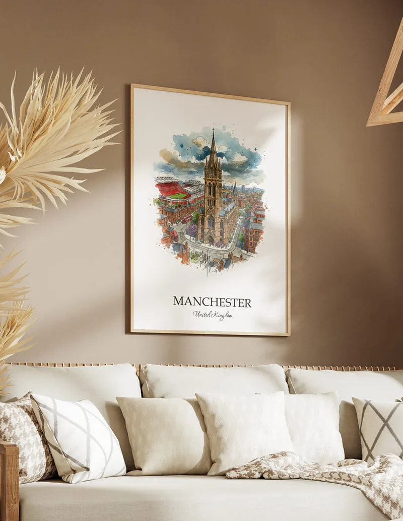 Vintage travel poster of Manchester city, United Kingdom in a light frame displayed above a sofa in a bright boho interior.