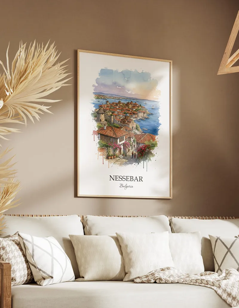 Vintage travel poster of Nessebar city, Bulgaria in a light frame displayed above a sofa in a bright boho interior.