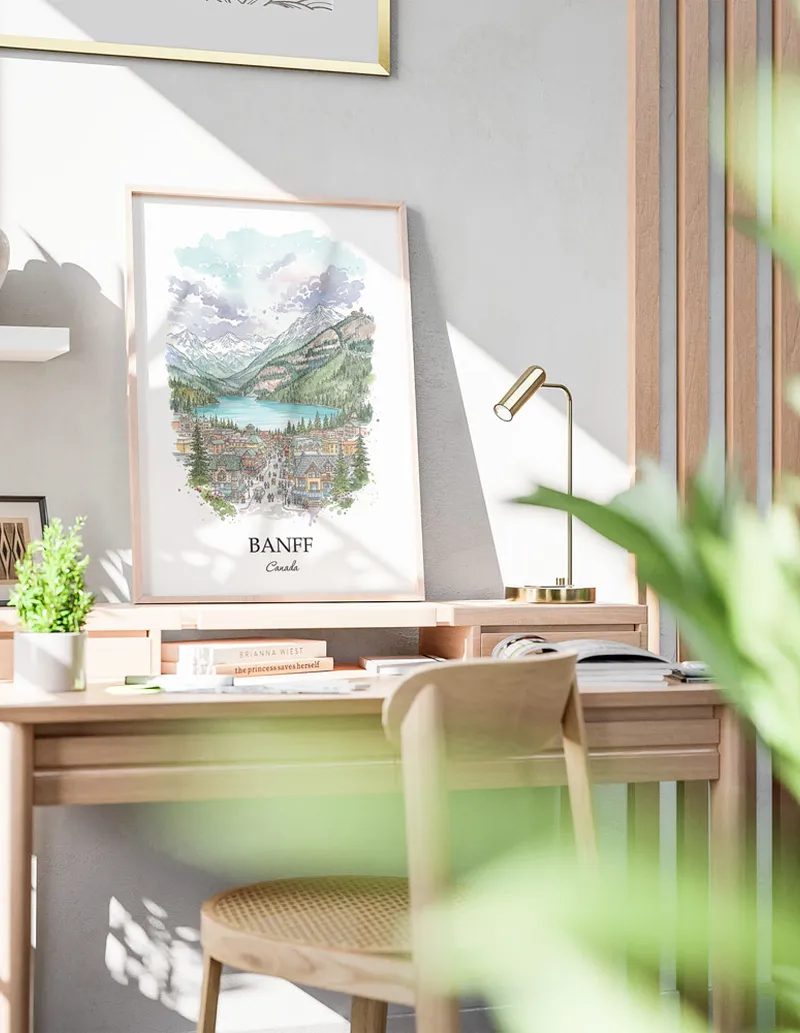 Cozy, well-lit workspace with a minimalist poster of Banff, Canada in a light frame sitting on the desk.