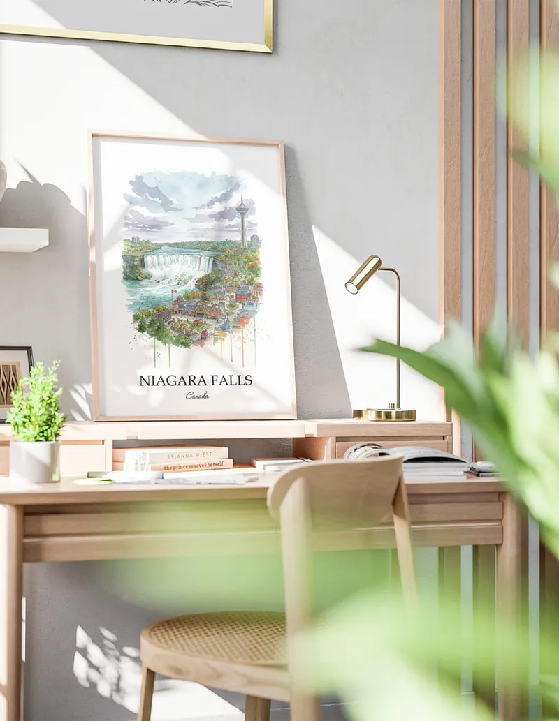 Cozy, well-lit workspace with a minimalist poster of Niagara Falls, Canada in a light frame sitting on the desk.