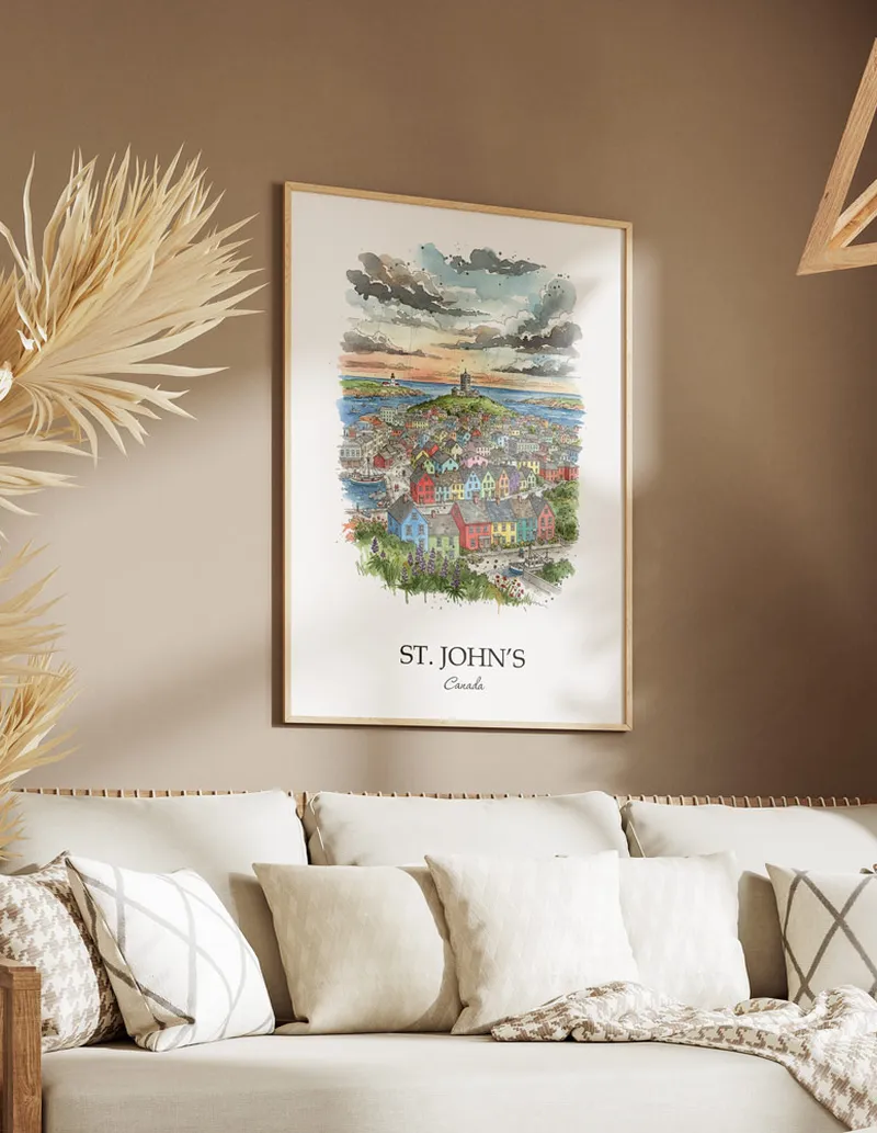 Vintage travel poster of St. John's city, Canada in a light frame displayed above a sofa in a bright boho interior.