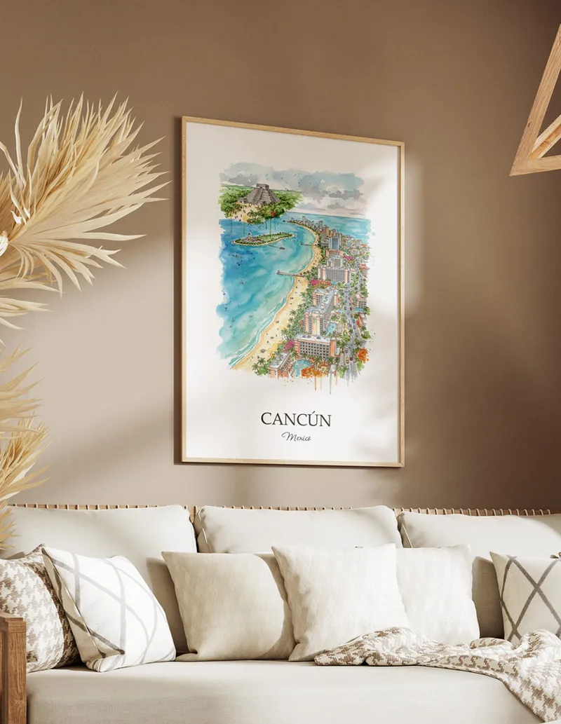 Vintage travel poster of Cancún city, Mexico in a light frame displayed above a sofa in a bright boho interior.
