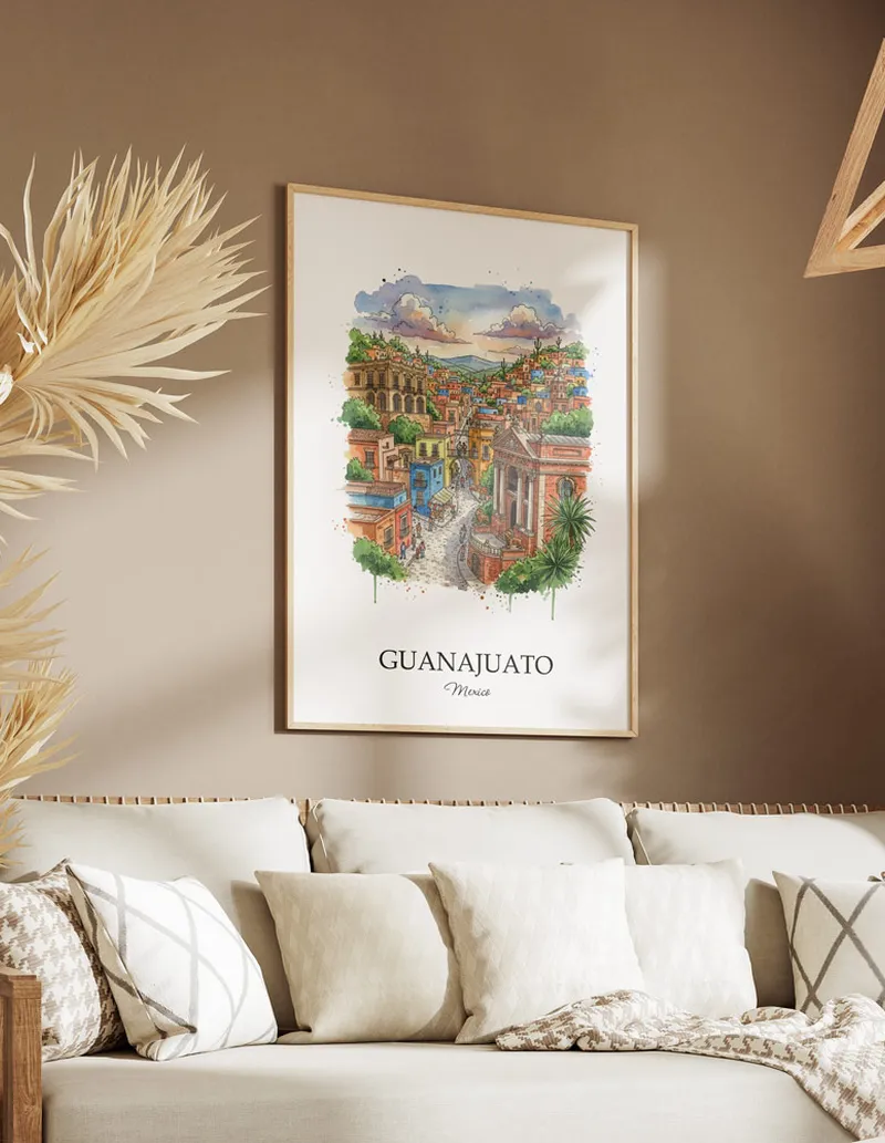 Vintage travel poster of Guanajuato city, Mexico in a light frame displayed above a sofa in a bright boho interior.