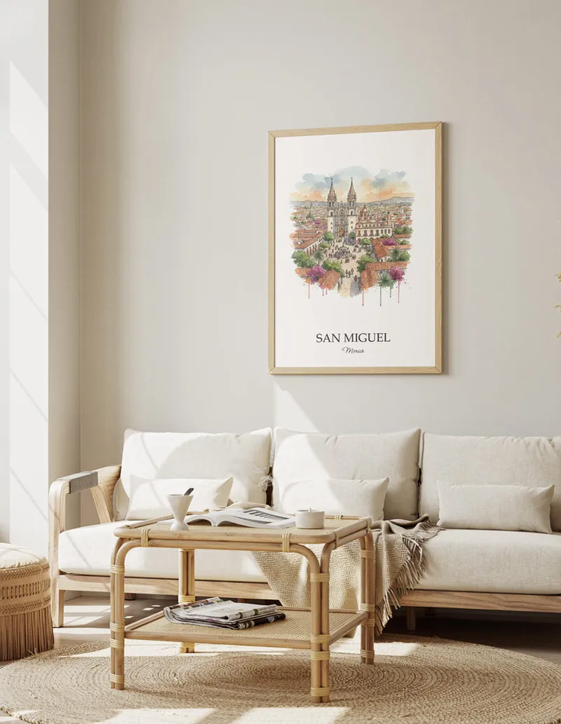 Framed wall art featuring San Miguel de Allende, Mexico in a light wood frame hanging above a sofa in a modern living room.