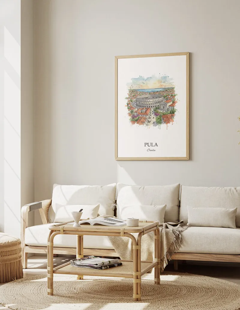 Framed wall art featuring Pula, Croatia in a light wood frame hanging above a sofa in a modern living room.