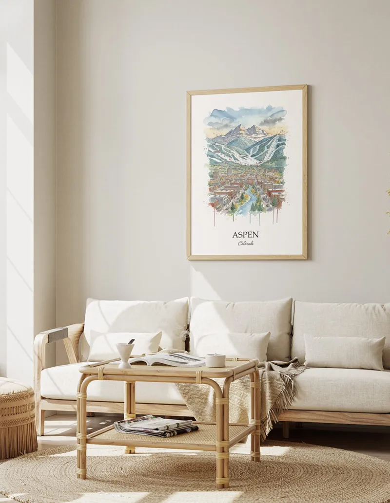 Framed wall art featuring Aspen, USA - Colorado in a light wood frame hanging above a sofa in a modern living room.