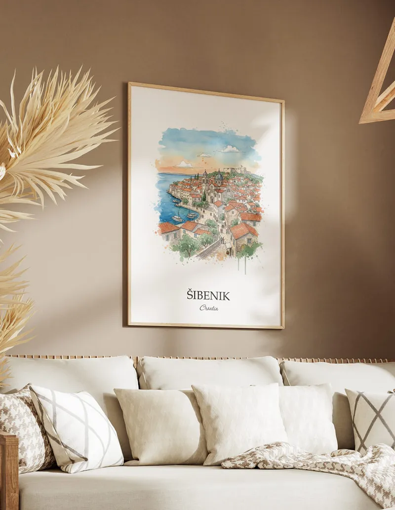 Vintage travel poster of _ibenik city, Croatia in a light frame displayed above a sofa in a bright boho interior.