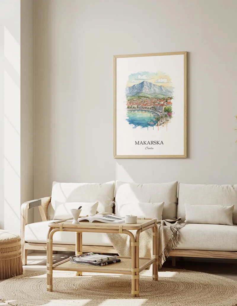 Framed wall art featuring Makarska, Croatia in a light wood frame hanging above a sofa in a modern living room.
