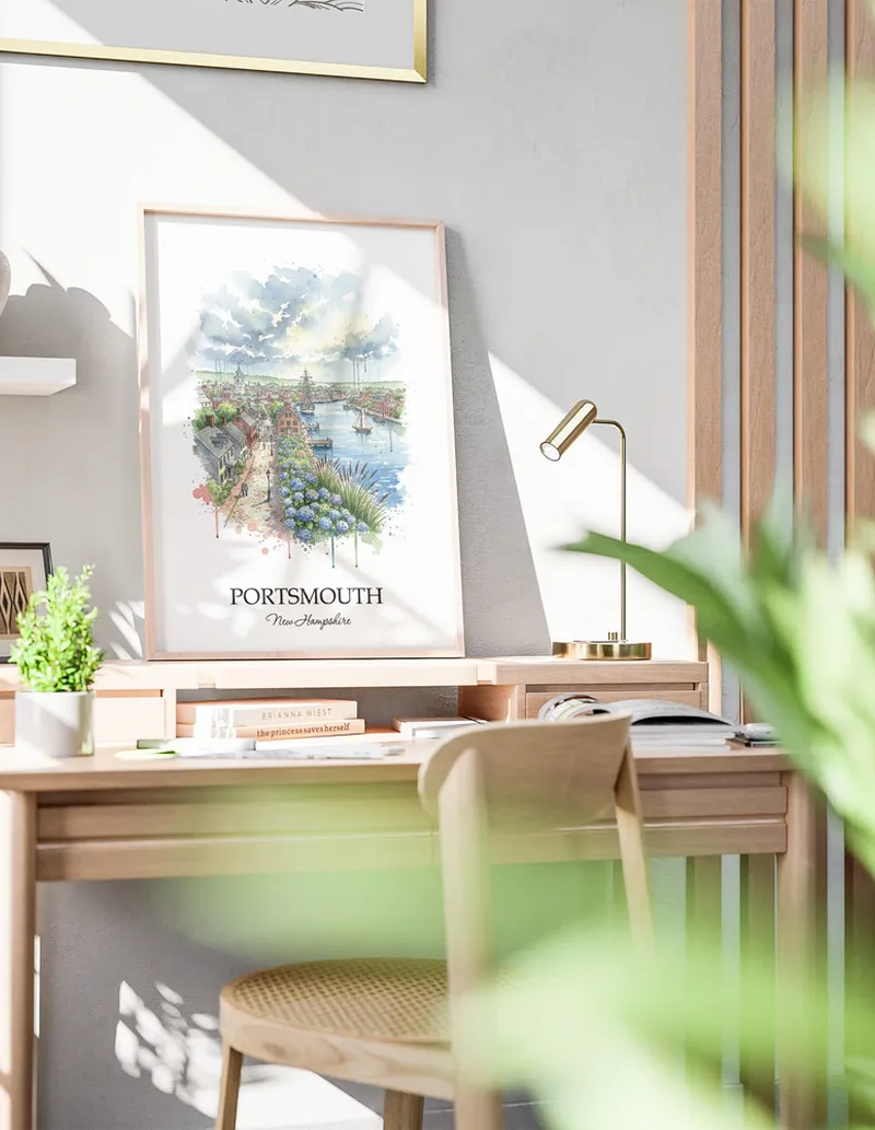 Cozy, well-lit workspace with a minimalist poster of Portsmouth, USA - New Hampshire in a light frame sitting on the desk.
