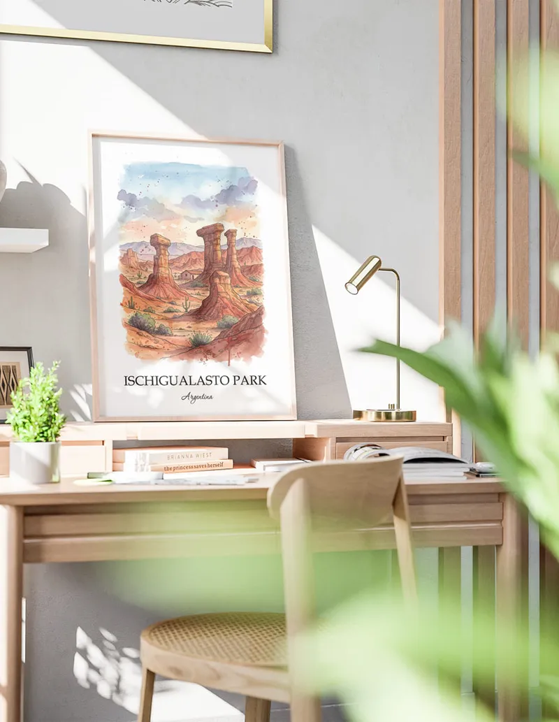 Cozy, well-lit workspace with a minimalist poster of Ischigualasto Park, Argentina in a light frame sitting on the desk.