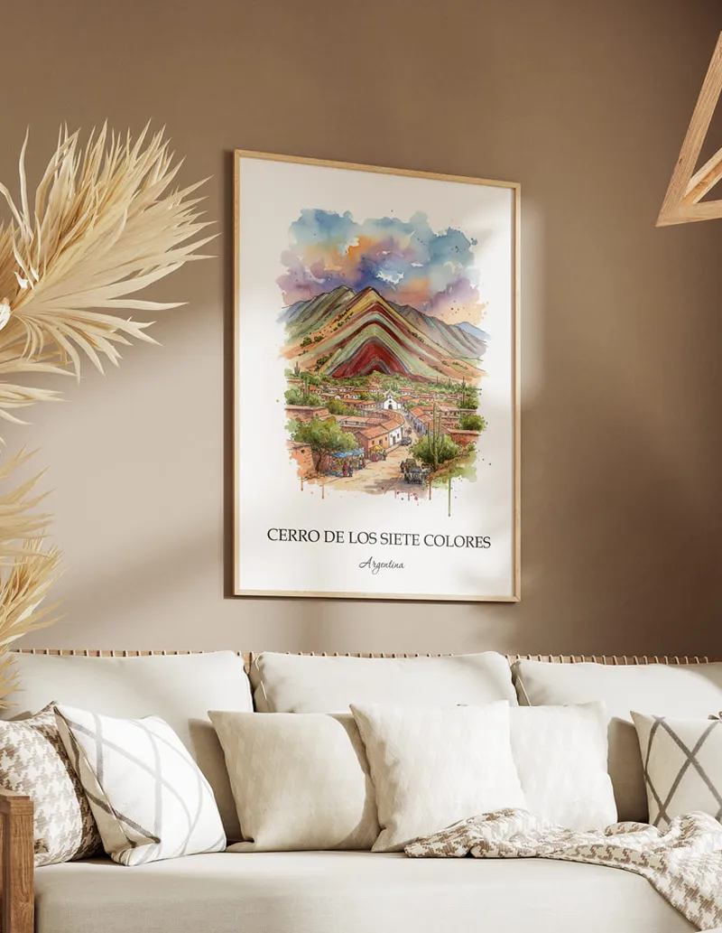Vintage travel poster of Cerro de los Siete Colores, Argentina in a light frame displayed above a sofa in a bright boho interior.