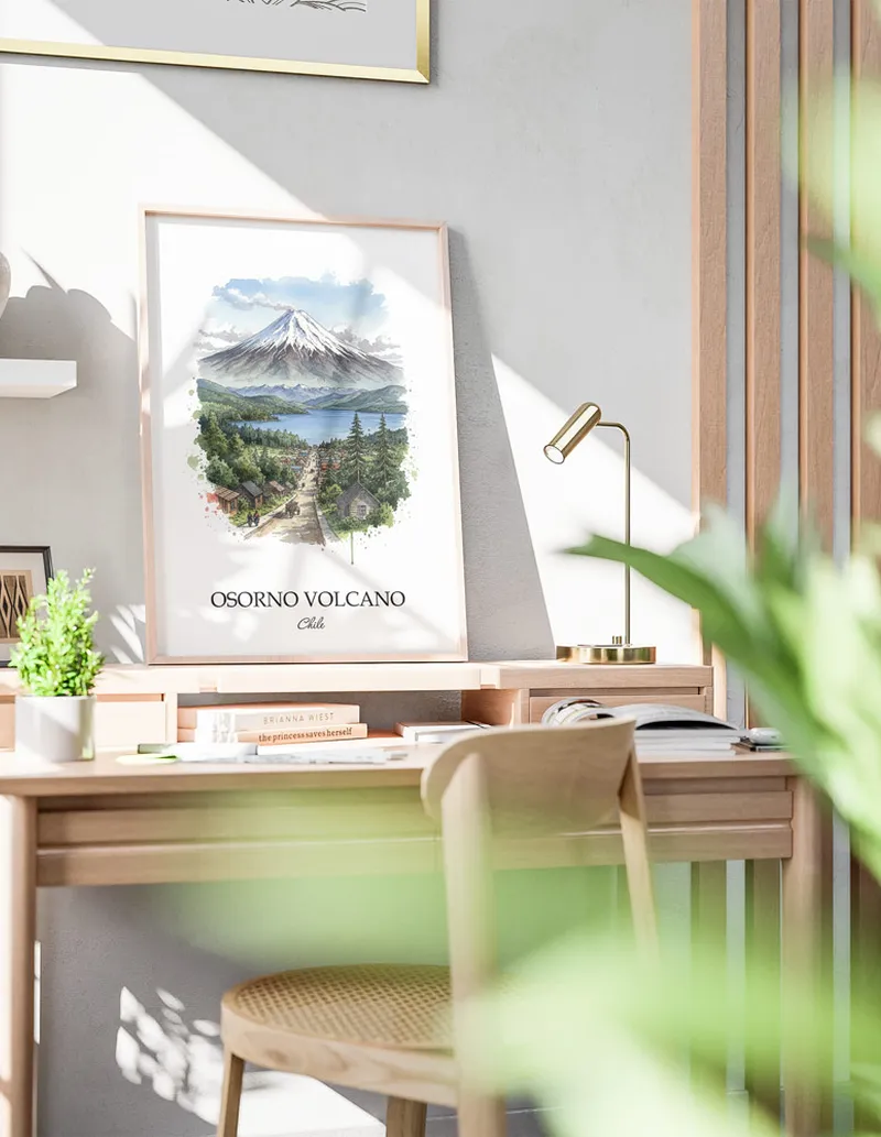 Cozy, well-lit workspace with a minimalist poster of Osorno Volcano, Chile in a light frame sitting on the desk.