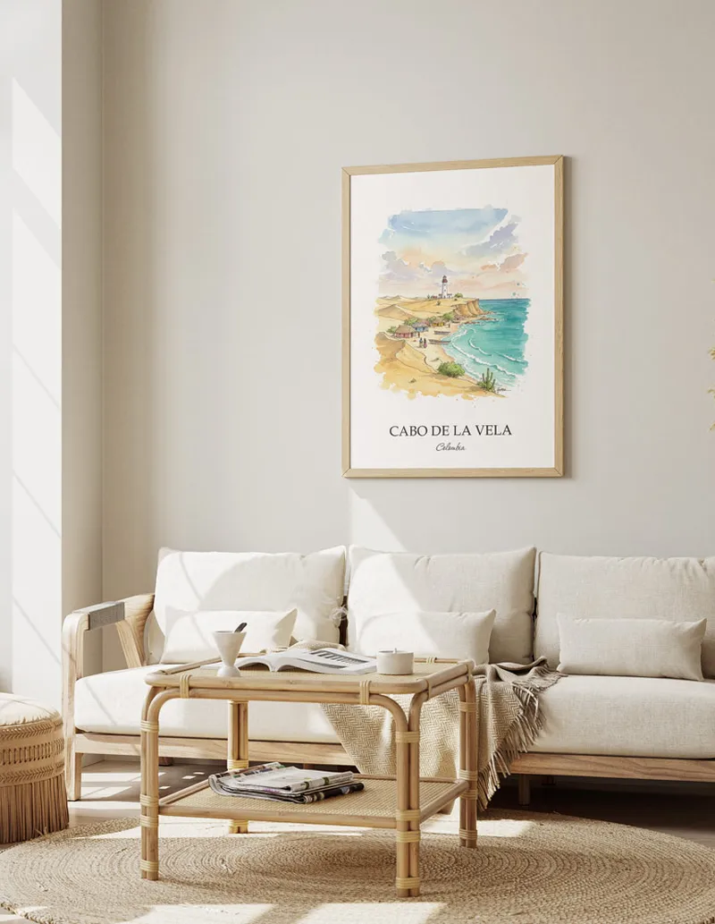Vintage travel poster of Cabo de la Vela, Colombia in a light frame displayed above a sofa in a bright boho interior.