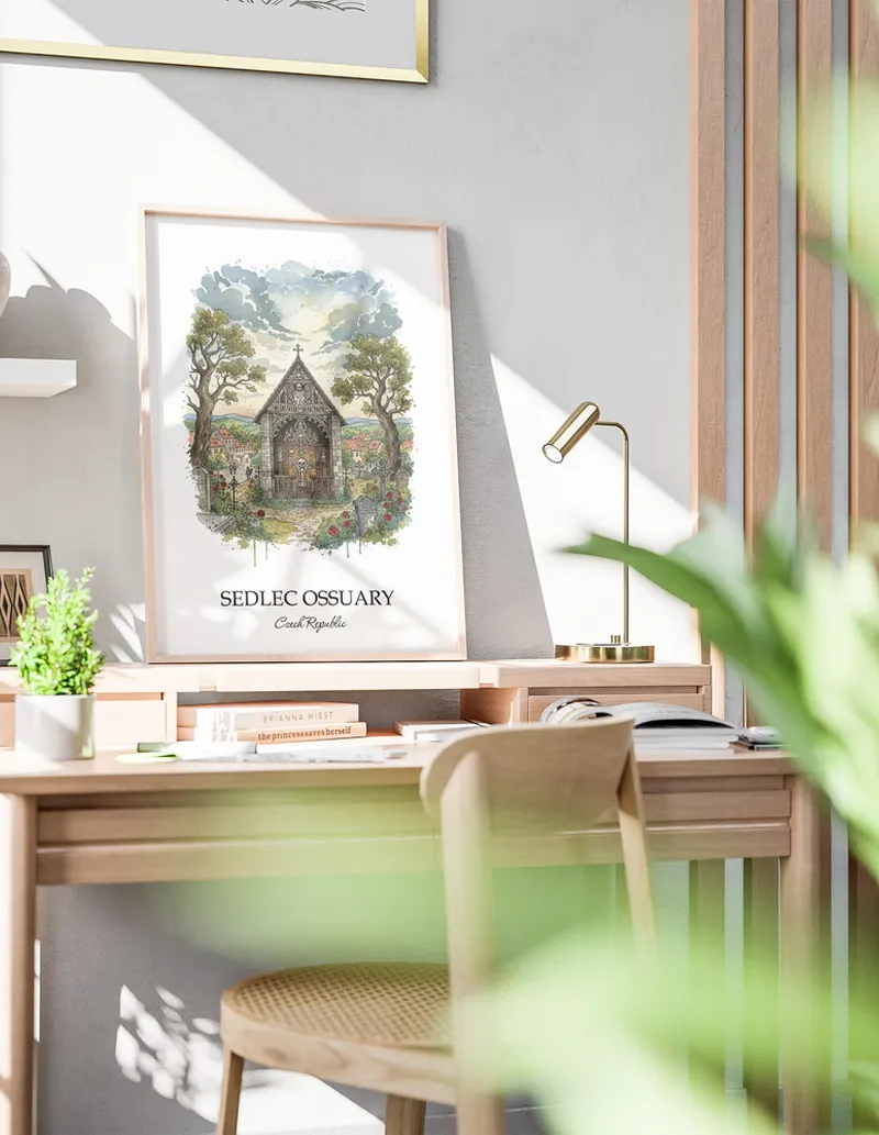 Cozy, well-lit workspace with a minimalist poster of Sedlec Ossuary, Czech Republic in a light frame sitting on the desk.