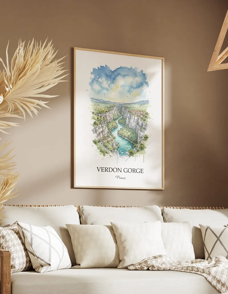 Vintage travel poster of Verdon Gorge, France in a light frame displayed above a sofa in a bright boho interior.