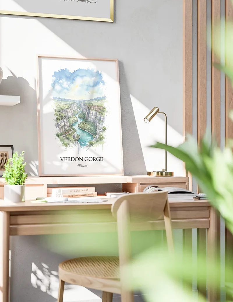 Cozy, well-lit workspace with a minimalist poster of Verdon Gorge, France in a light frame sitting on the desk.
