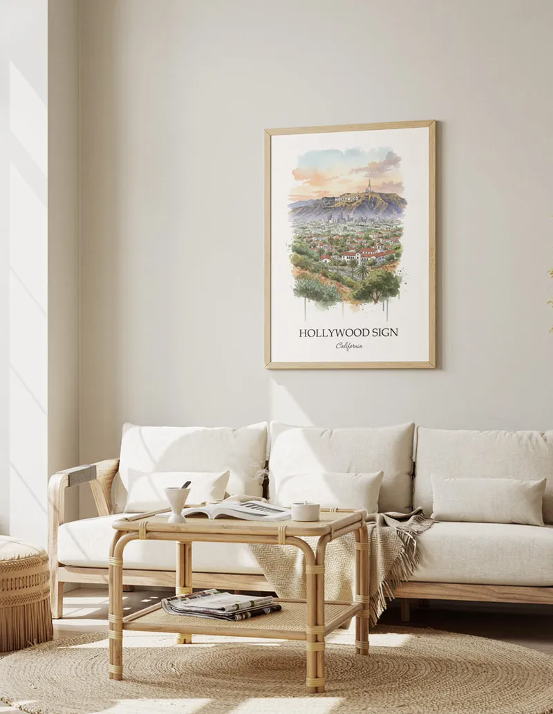 Vintage travel poster of Hollywood Sign, California in a light frame displayed above a sofa in a bright boho interior.