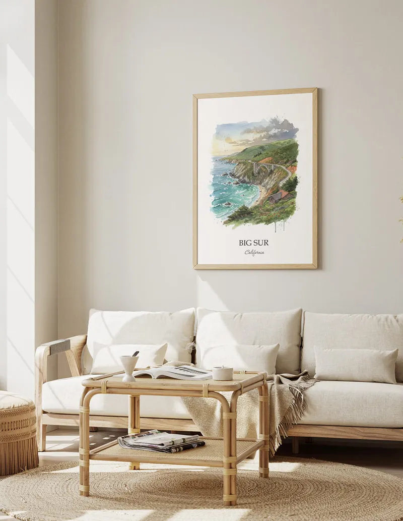 Vintage travel poster of Big Sur, California in a light frame displayed above a sofa in a bright boho interior.