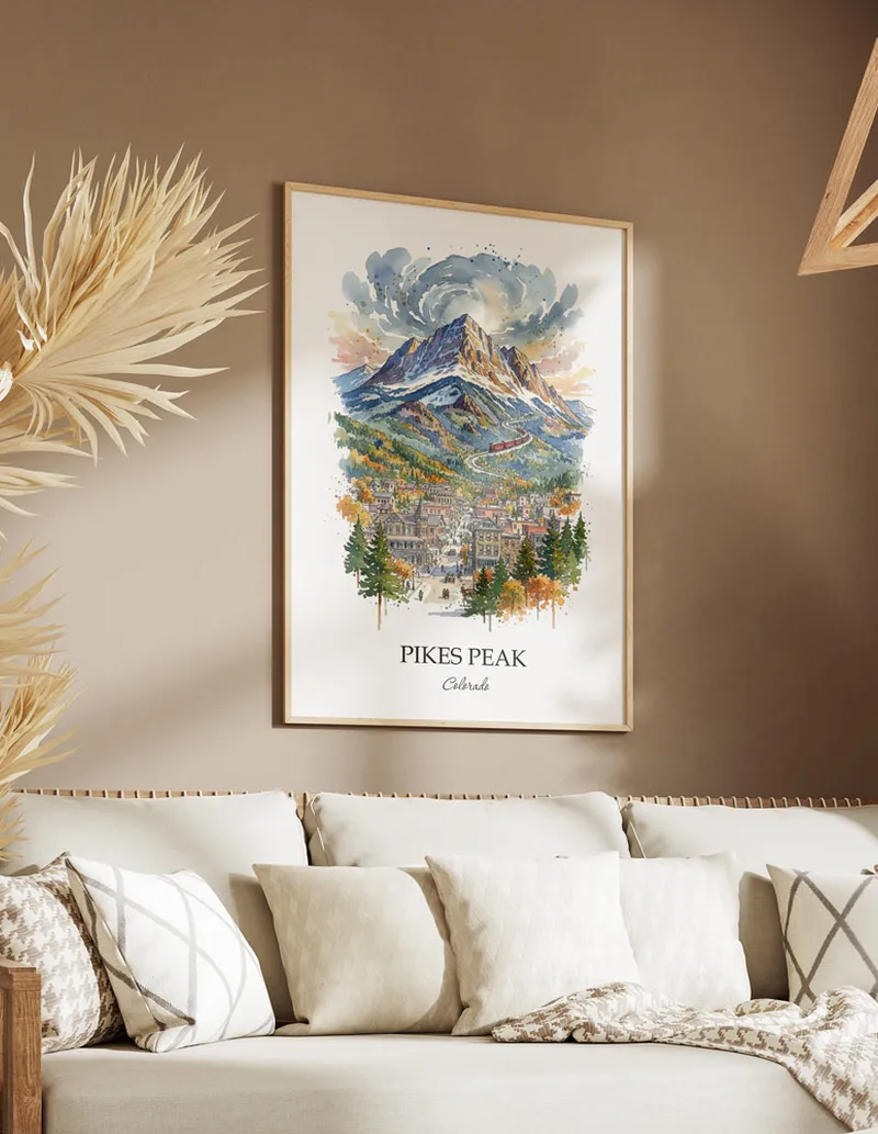 Cozy, well-lit workspace with a minimalist poster of Pikes Peak, Colorado in a light frame sitting on the desk.