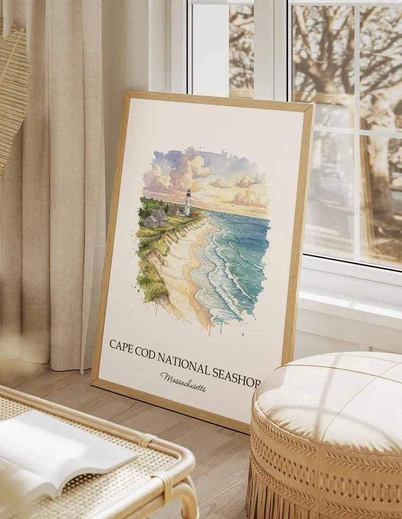 Vintage travel poster of Cape Cod National Seashore, Massachusetts in a light frame displayed above a sofa in a bright boho interior.