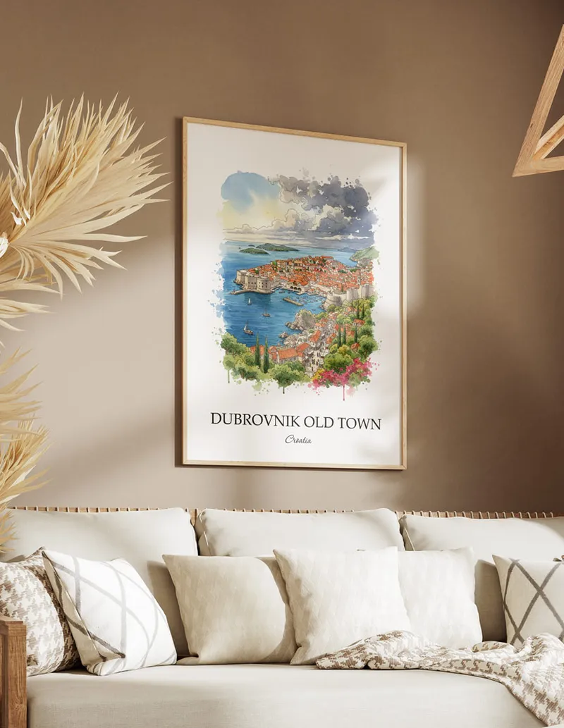 Vintage travel poster of Dubrovnik Old Town, Croatia in a light frame displayed above a sofa in a bright boho interior.