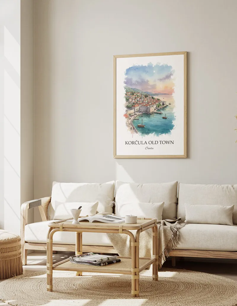 Framed wall art featuring Kor_ula Old Town, Croatia in a light wood frame hanging above a sofa in a modern living room.