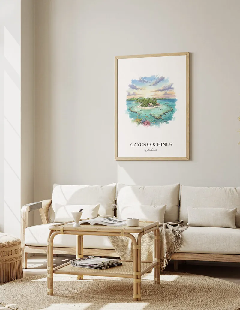 Cozy, well-lit workspace with a minimalist poster of Cayos Cochinos, Honduras in a light frame sitting on the desk.