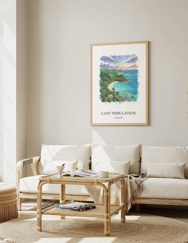 Cozy, well-lit workspace with a minimalist poster of Cape Tribulation, Australia in a light frame sitting on the desk.