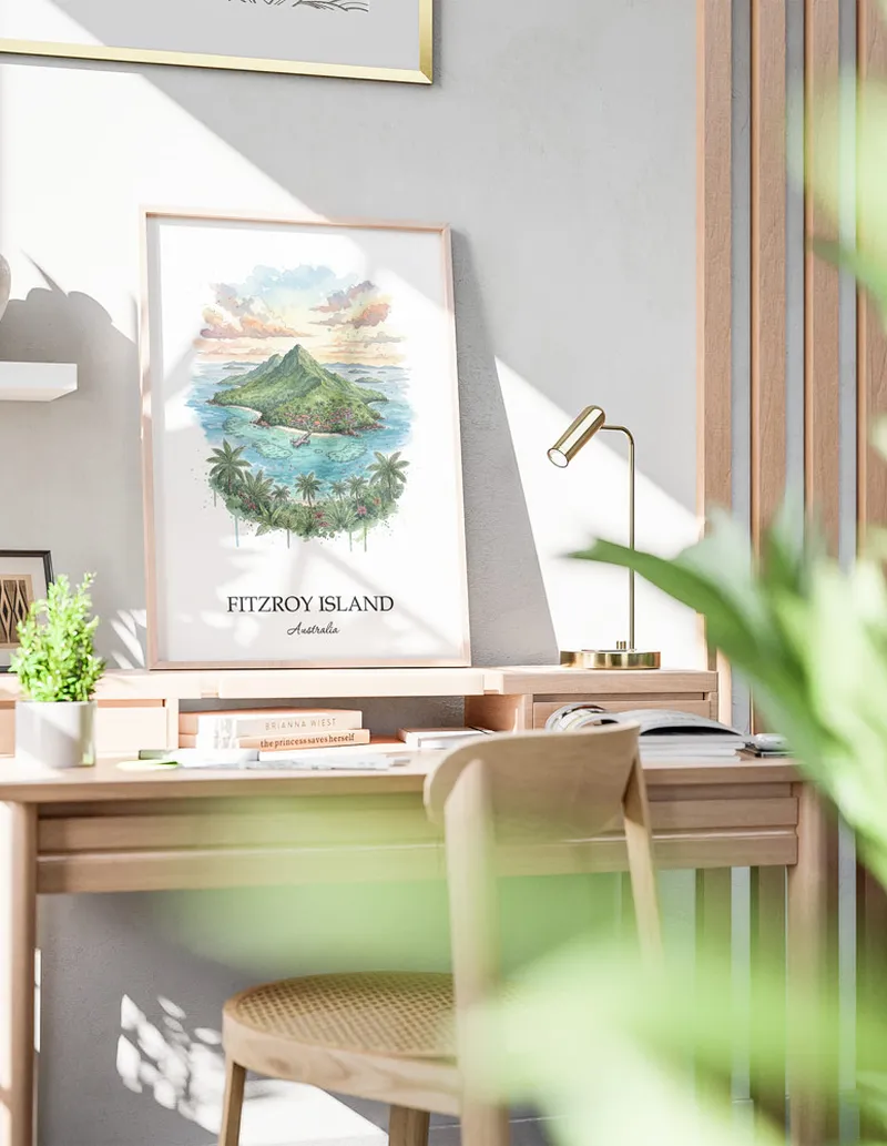 Minimalist poster of Fitzroy Island in Australia in a light frame standing on the floor in a dark moody interior.