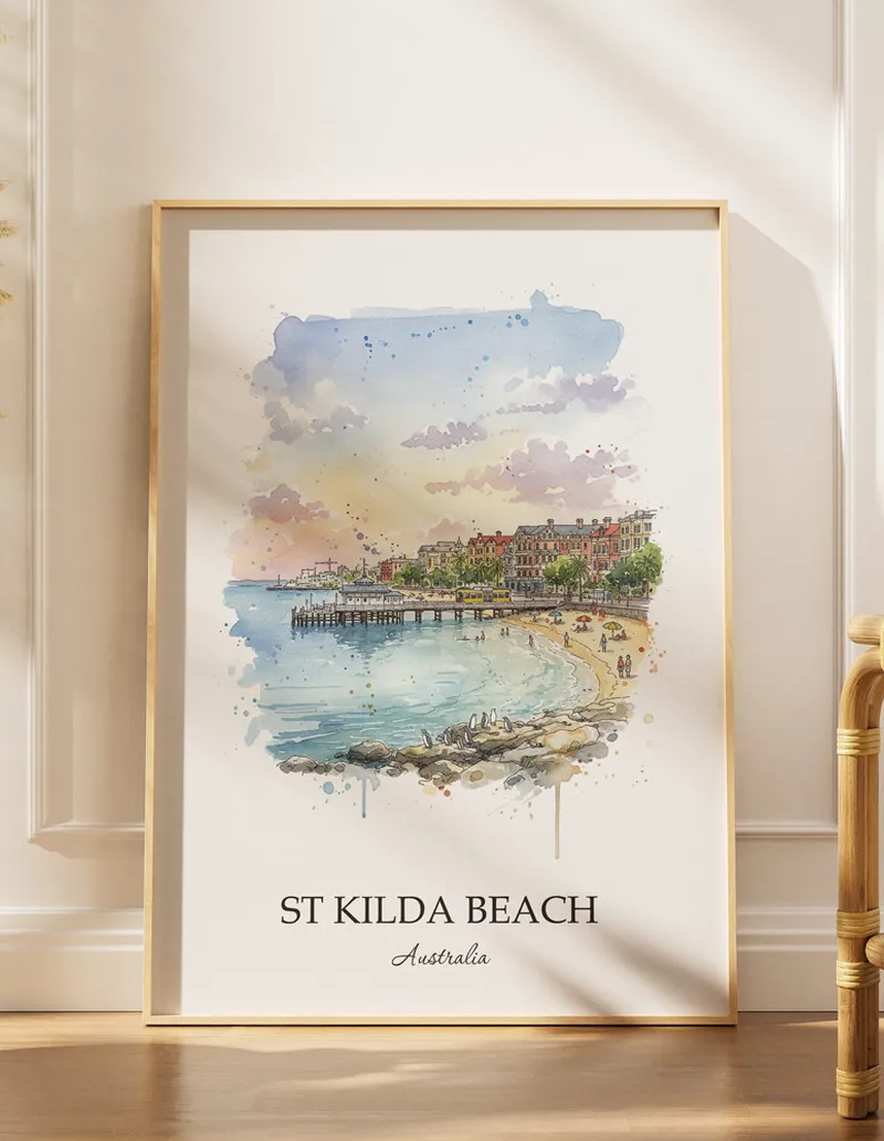 Framed wall art featuring St Kilda Beach, Australia in a light wood frame hanging above a sofa in a modern living room.