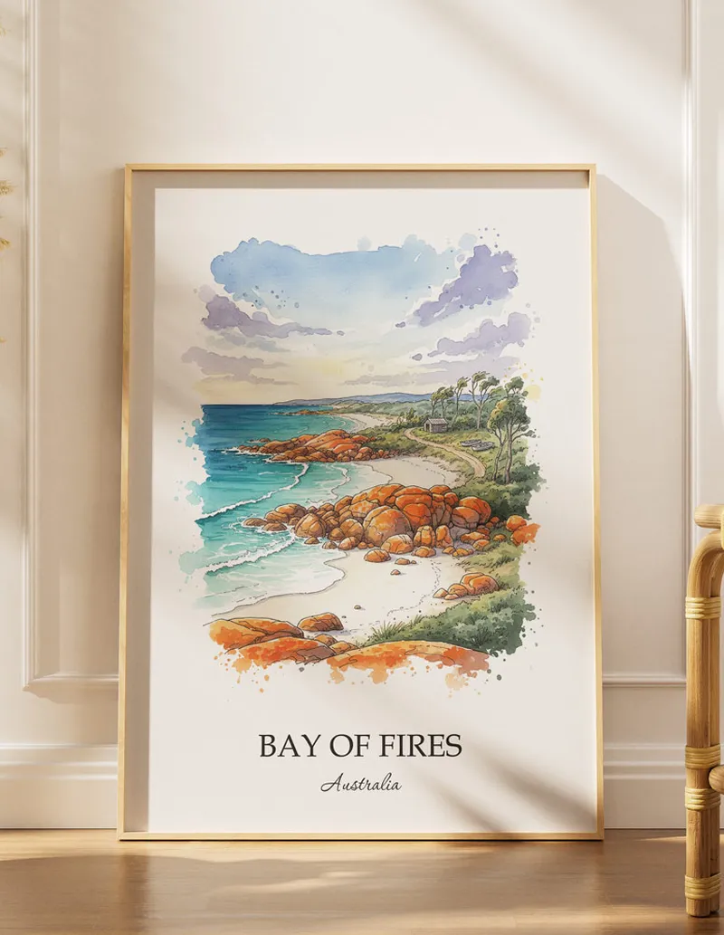 Framed wall art featuring Bay of Fires, Australia in a light wood frame hanging above a sofa in a modern living room.