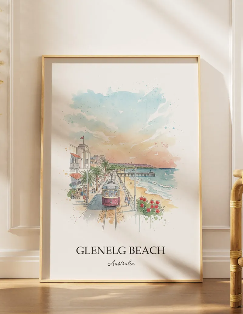 Framed wall art featuring Glenelg Beach, Australia in a light wood frame hanging above a sofa in a modern living room.