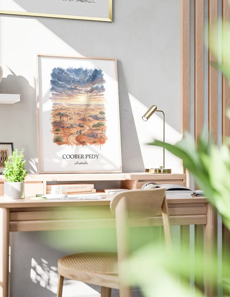 Minimalist poster of Coober Pedy in Australia in a light frame standing on the floor in a dark moody interior.