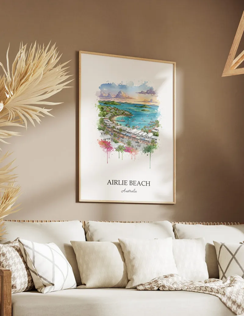 Minimalist poster of Airlie Beach in Australia in a light frame standing on the floor in a dark moody interior.